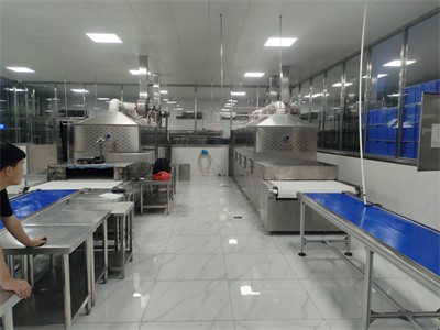 Microwave tunnel oven for heating student meals in barrels